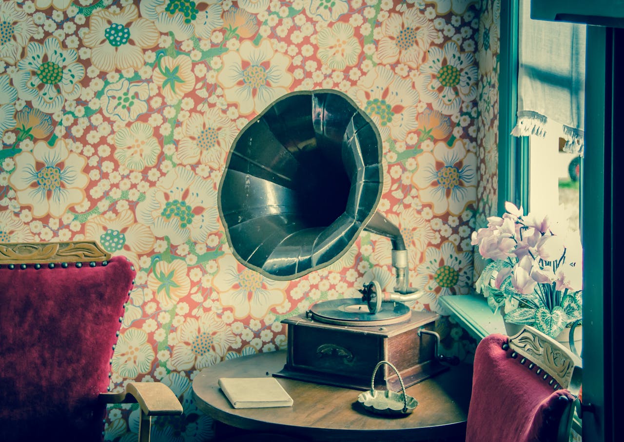 Retro gramophone in a room with floral wallpaper and vintage decor.